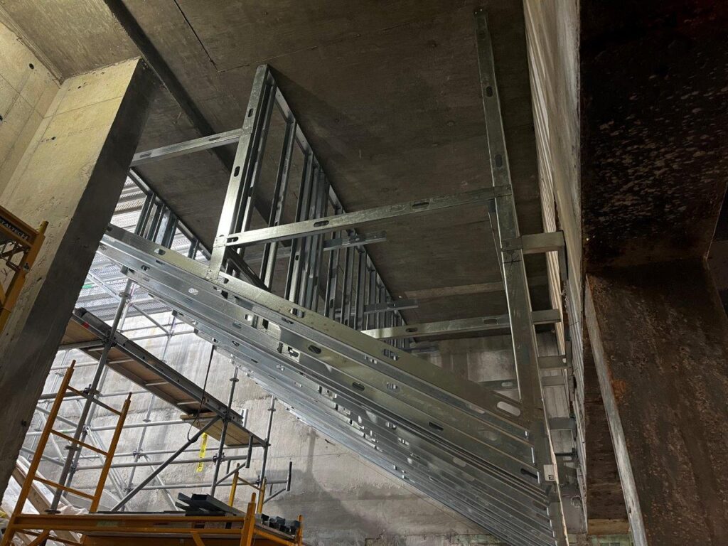 Cold-form framing has been installed above the Entrance Staircases in advance of architectural panel installation.