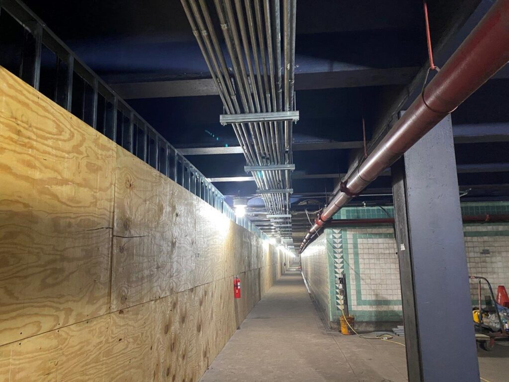 Electrical conduit installation along the Track 1 ceiling is ongoing.